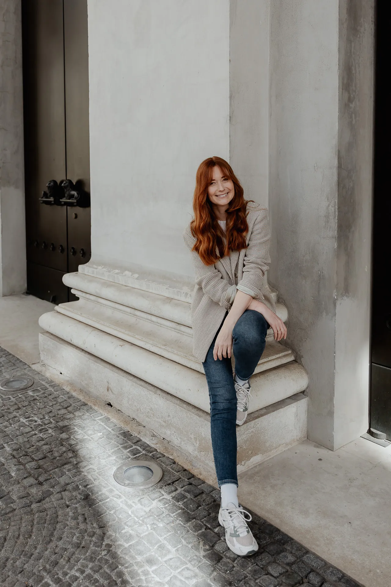Lena Dugnus Hochzeitsfotografin sitzt auf Marmorstufen in historischem Gebäude