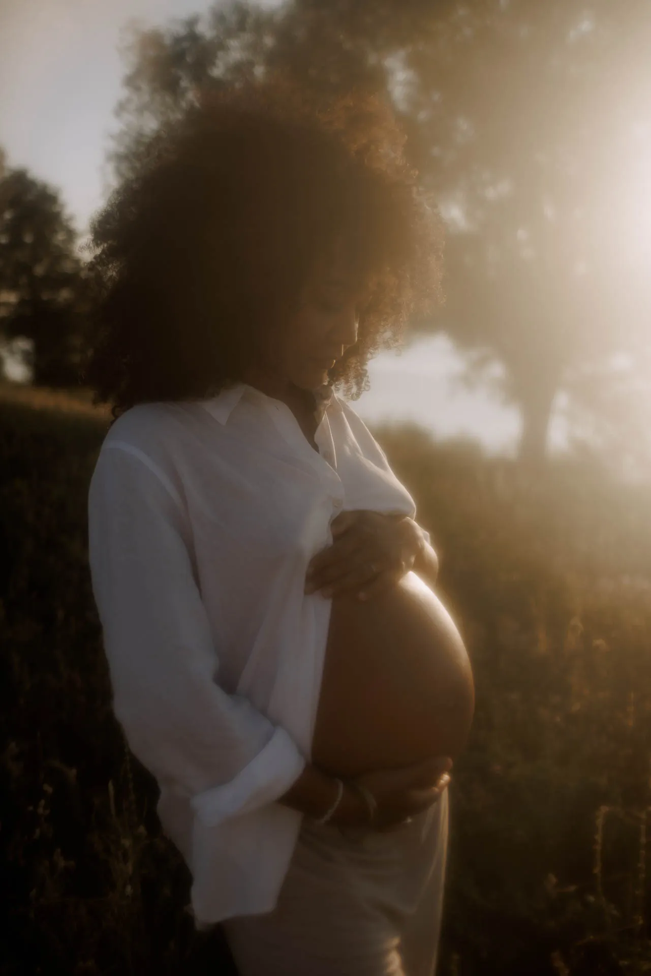 Babybauch-Porträt im Wasser mit goldenem Abendlicht München
