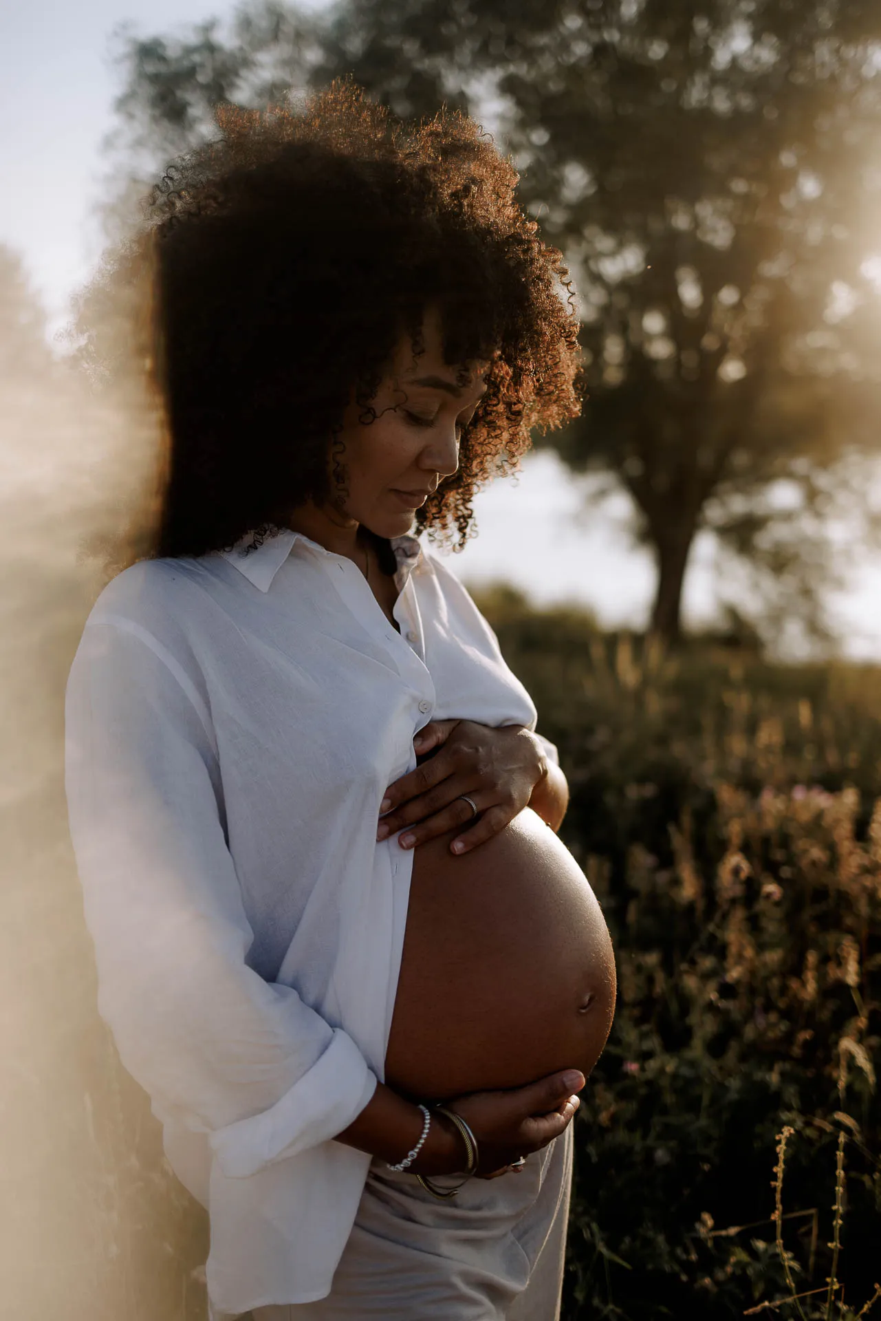 Schwangeres Paar im Wasser bei Sonnenuntergang München