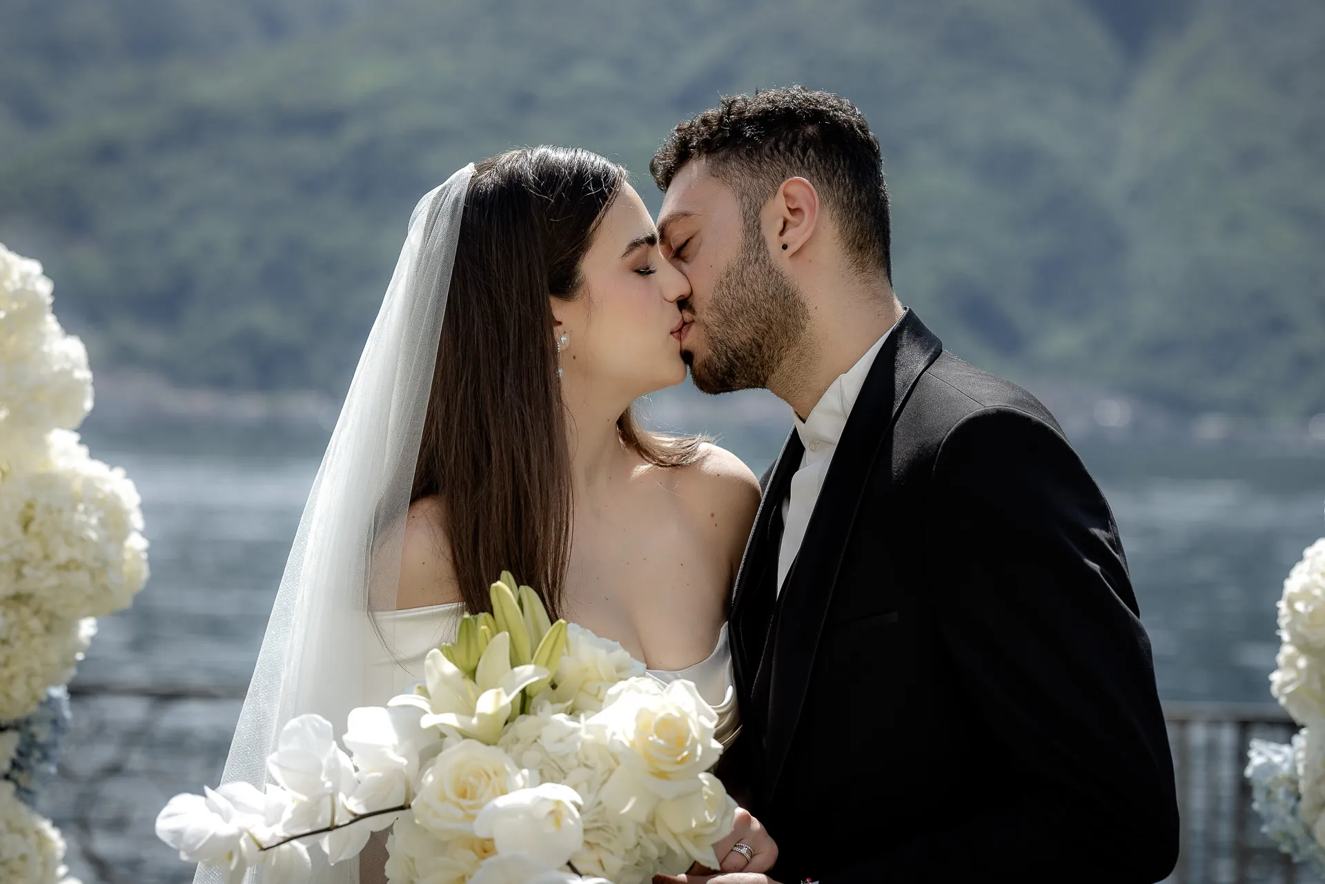 Brautpaar-Kuss nach Trauung am Comer See mit Orchideen-Strauß