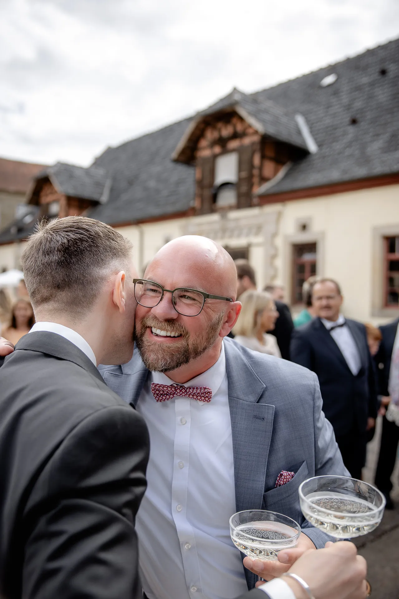 Fröhliche Hochzeitsgäste mit Champagner bei Gratulation am Schloss Eyrichshof