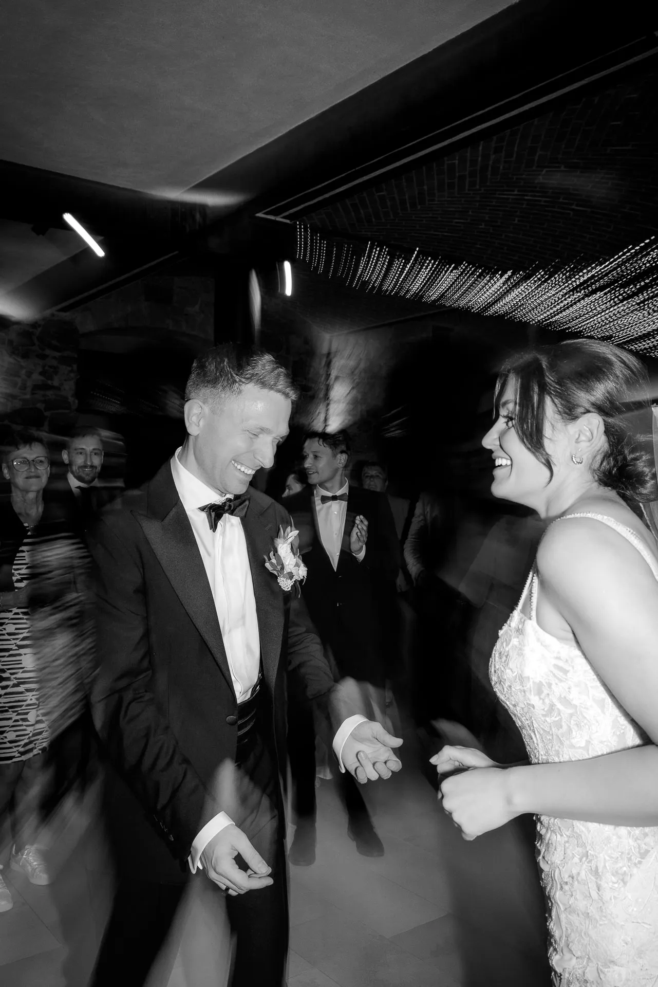 Brautpaar tanzt bei Hochzeitsparty am Schloss Eyrichshof in Schwarz-Weiß mit Gästen