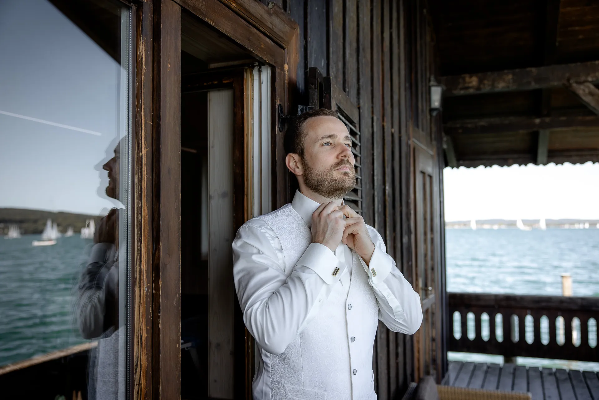Bräutigam beim Krawatte binden am Bootshaus mit Seeblick La Villa