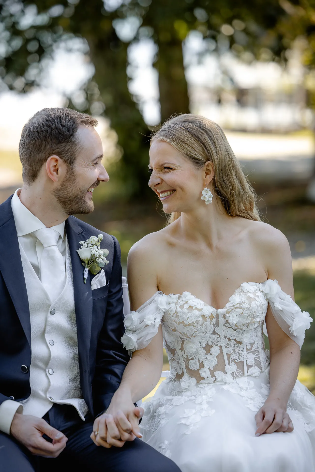 Glückliches Brautpaar sitzt zusammen lächelnd La Villa Garten