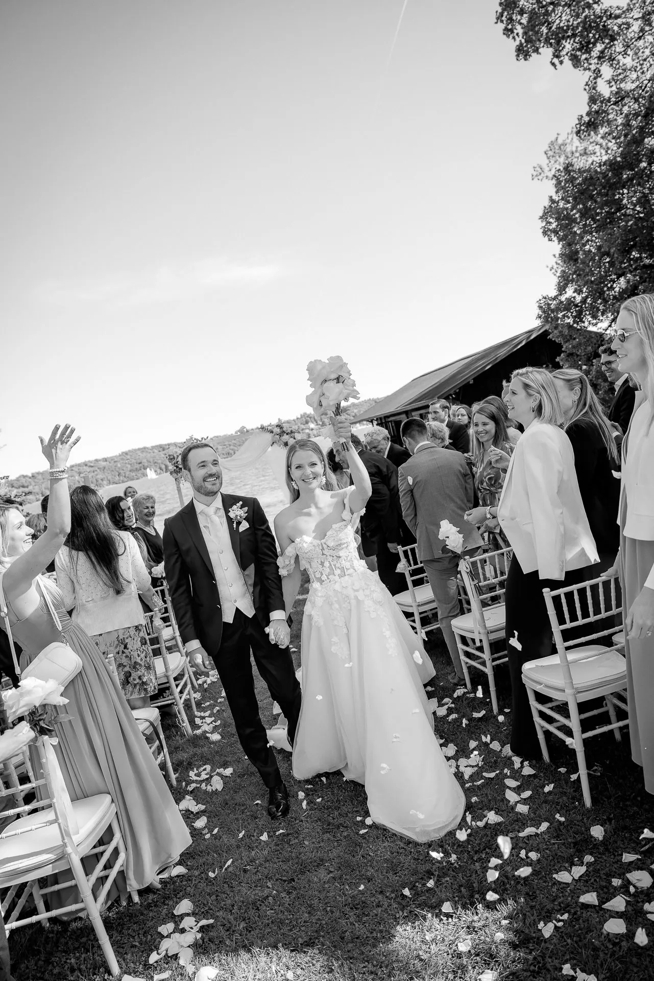 Jubelndes Brautpaar beim Auszug nach Trauung mit Hochzeitsgästen