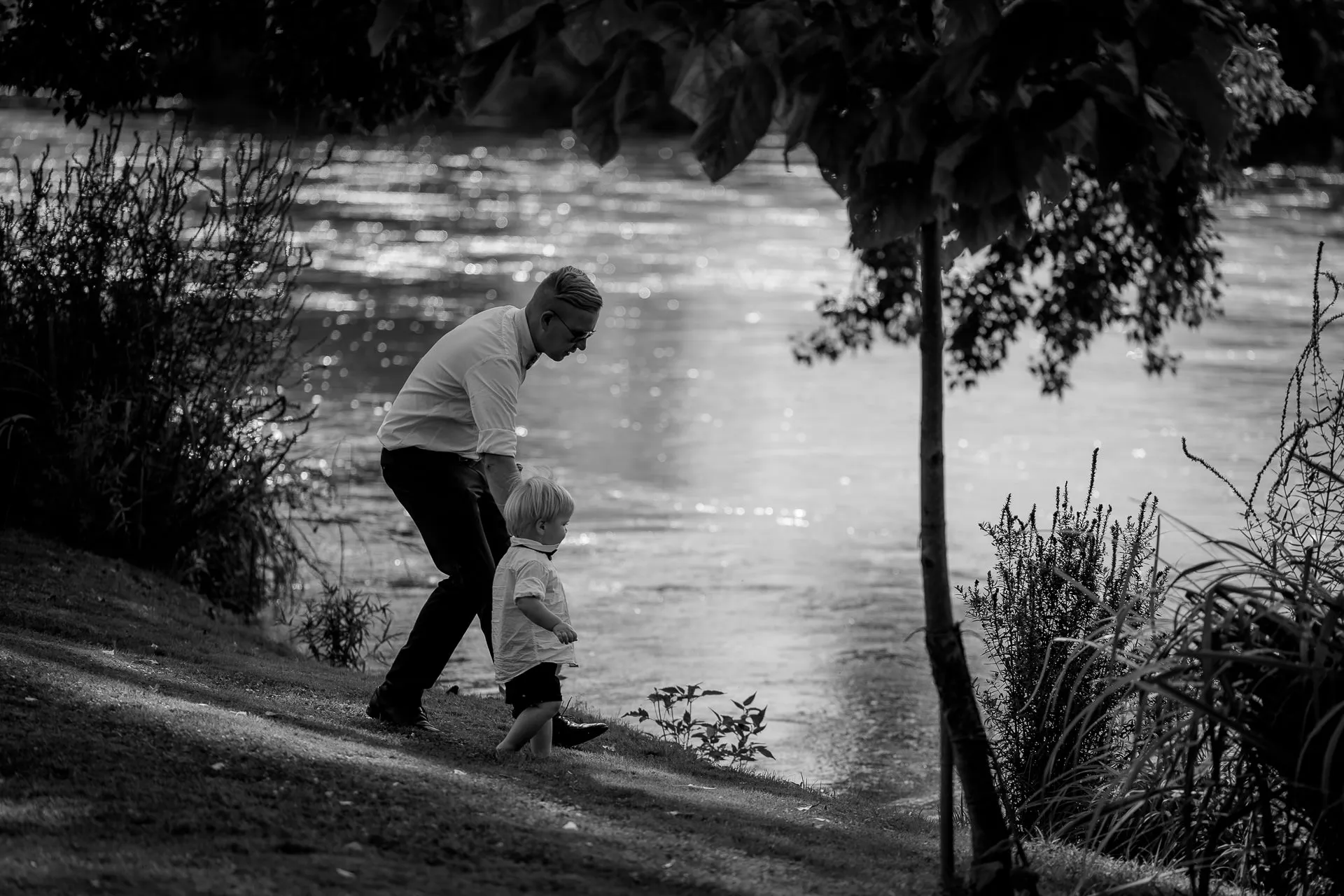 Großmutter und Enkel in innigem Moment am Fluss während italienischer Hochzeit