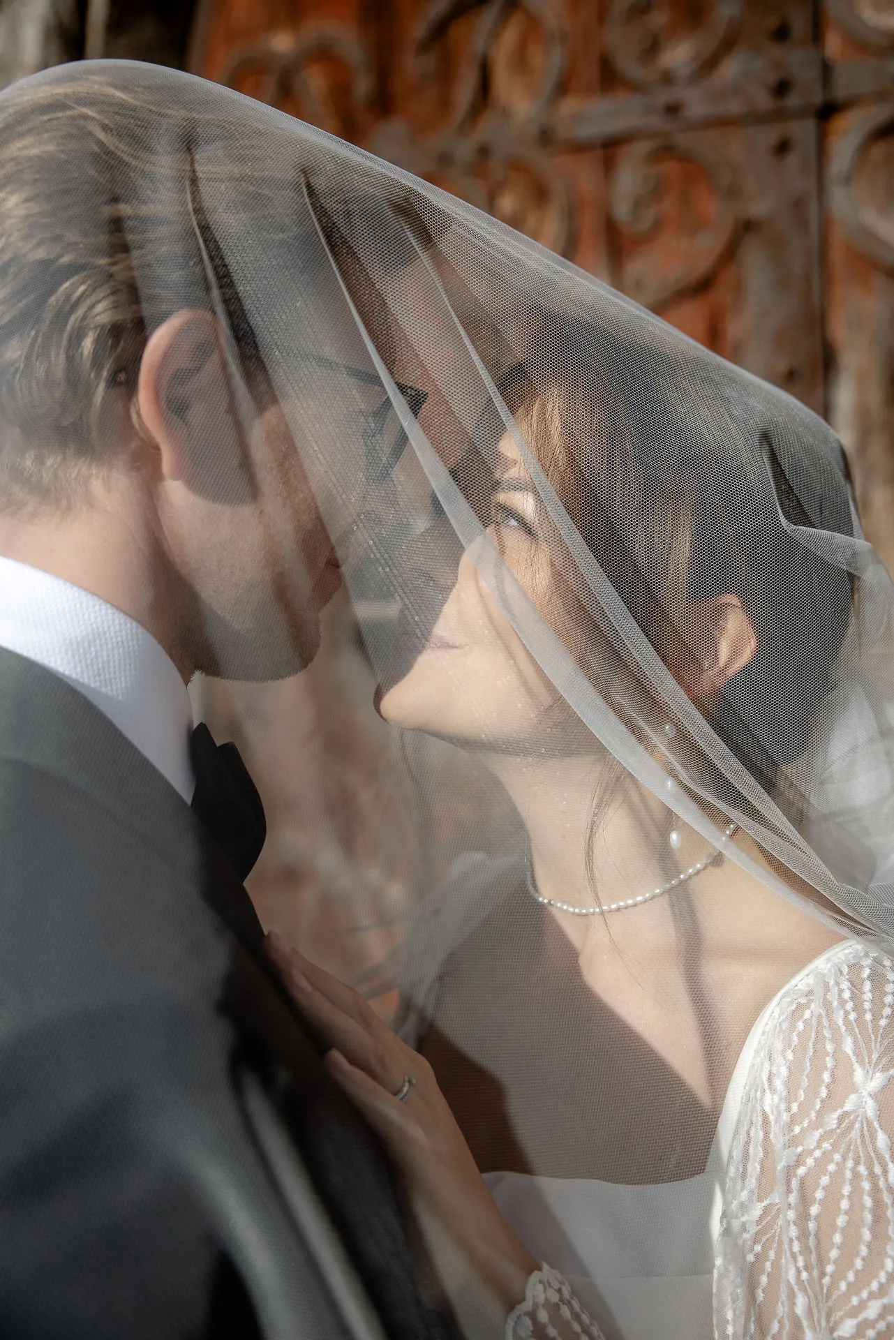 Romantisches Brautpaar unter Hochzeitsschleier bei Landhochzeit auf Gut Sonnenhausen