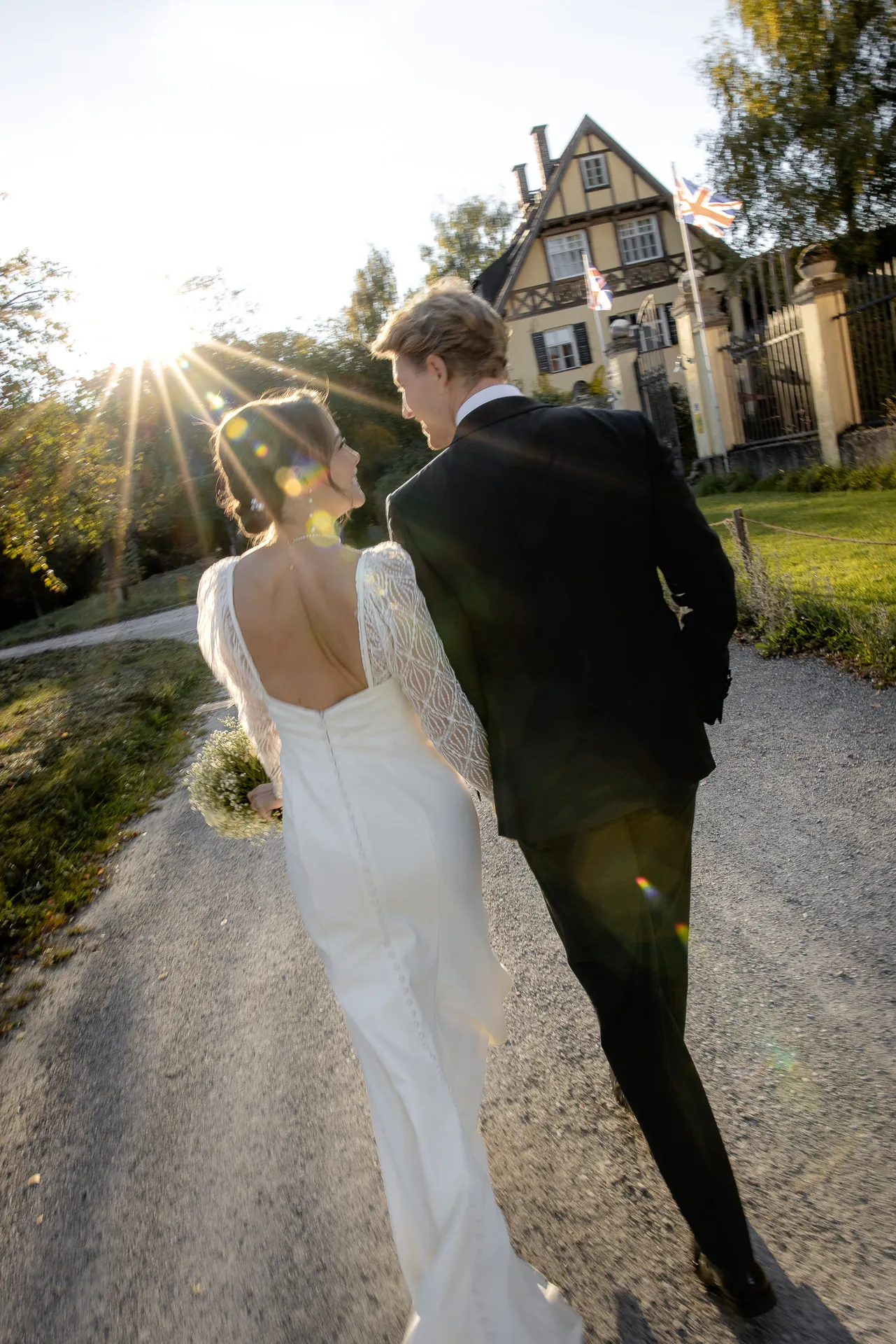 Brautpaar geht Arm in Arm bei goldenem Licht auf Gut Sonnenhausen Landhochzeit