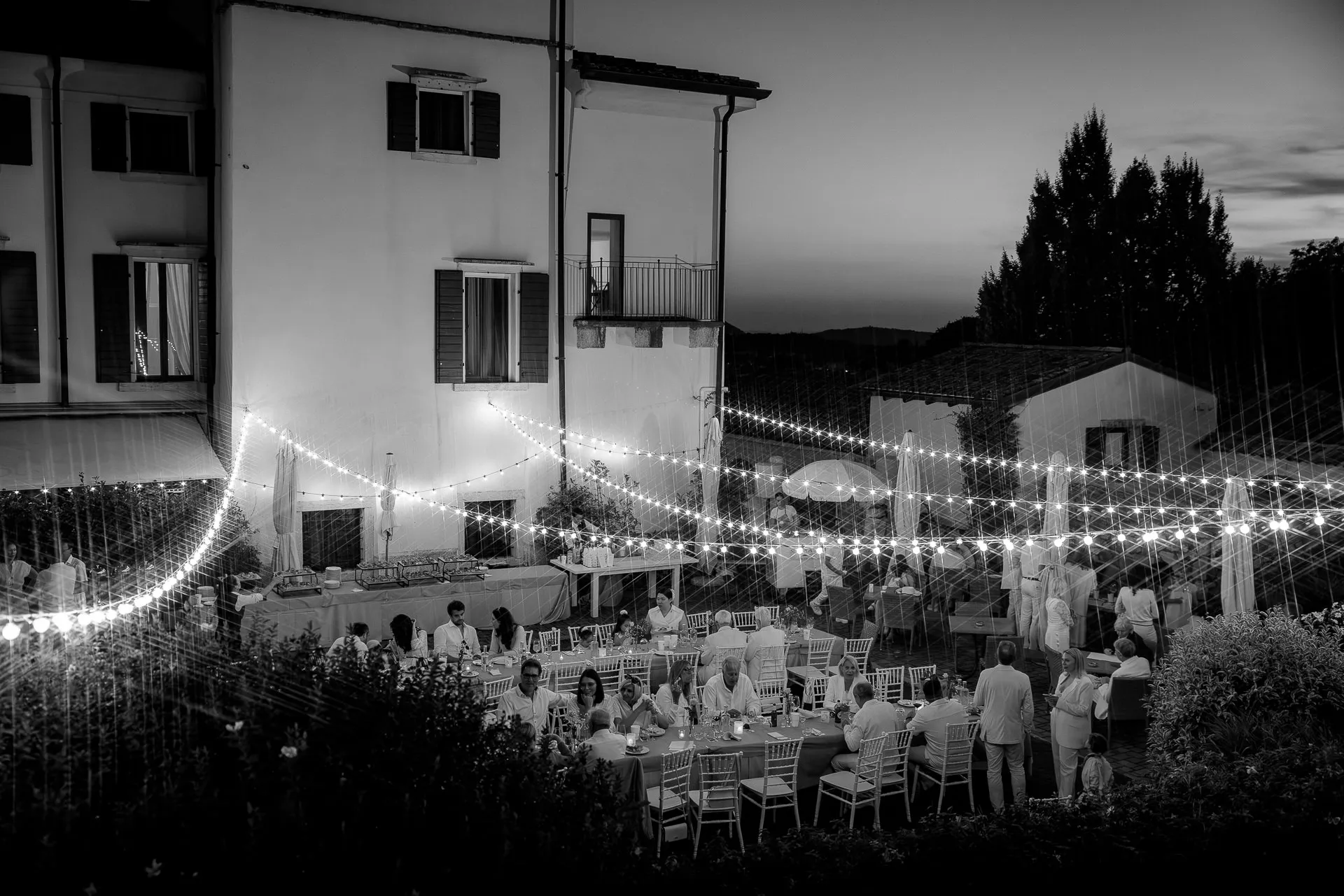 Stimmungsvolle Hochzeitsfeier bei Dämmerung mit Lichterketten in der Villa Cariola