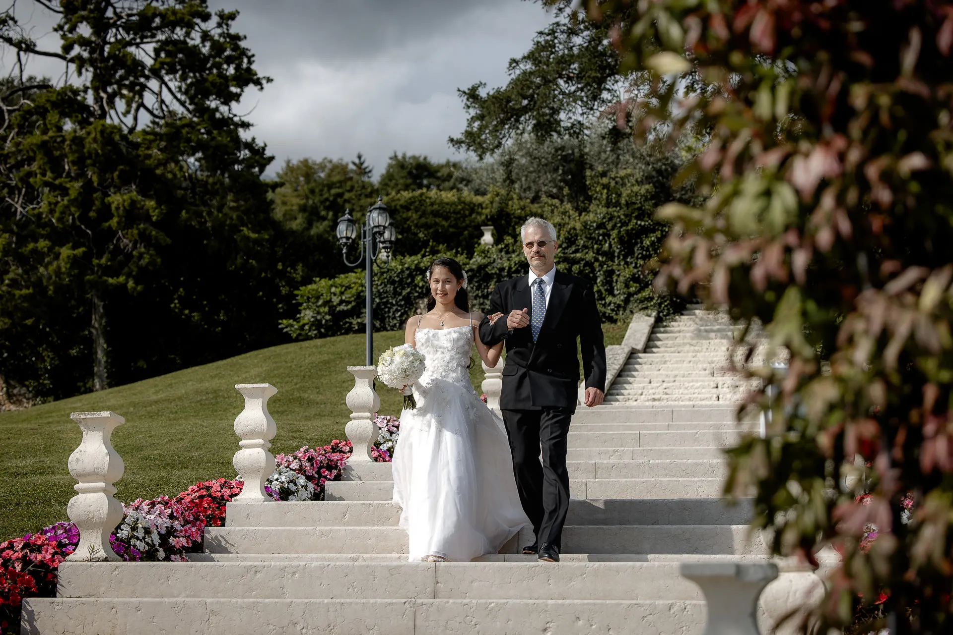 Braut mit Vater auf der Treppe der Villa Cariola zum Trauungsgang