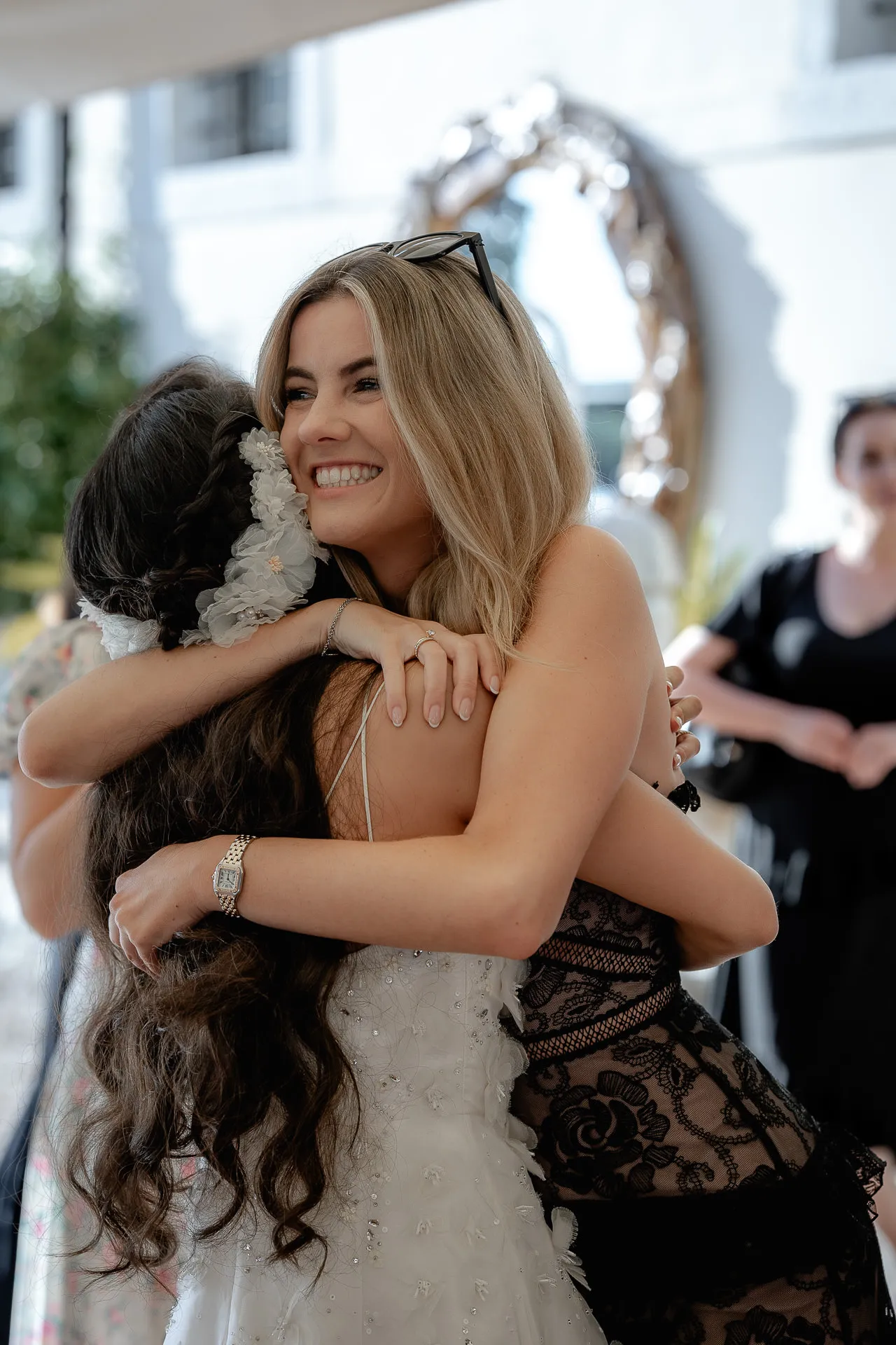 Strahlende Braut umarmt fröhlichen Hochzeitsgast bei der Feier in der Villa Cariola