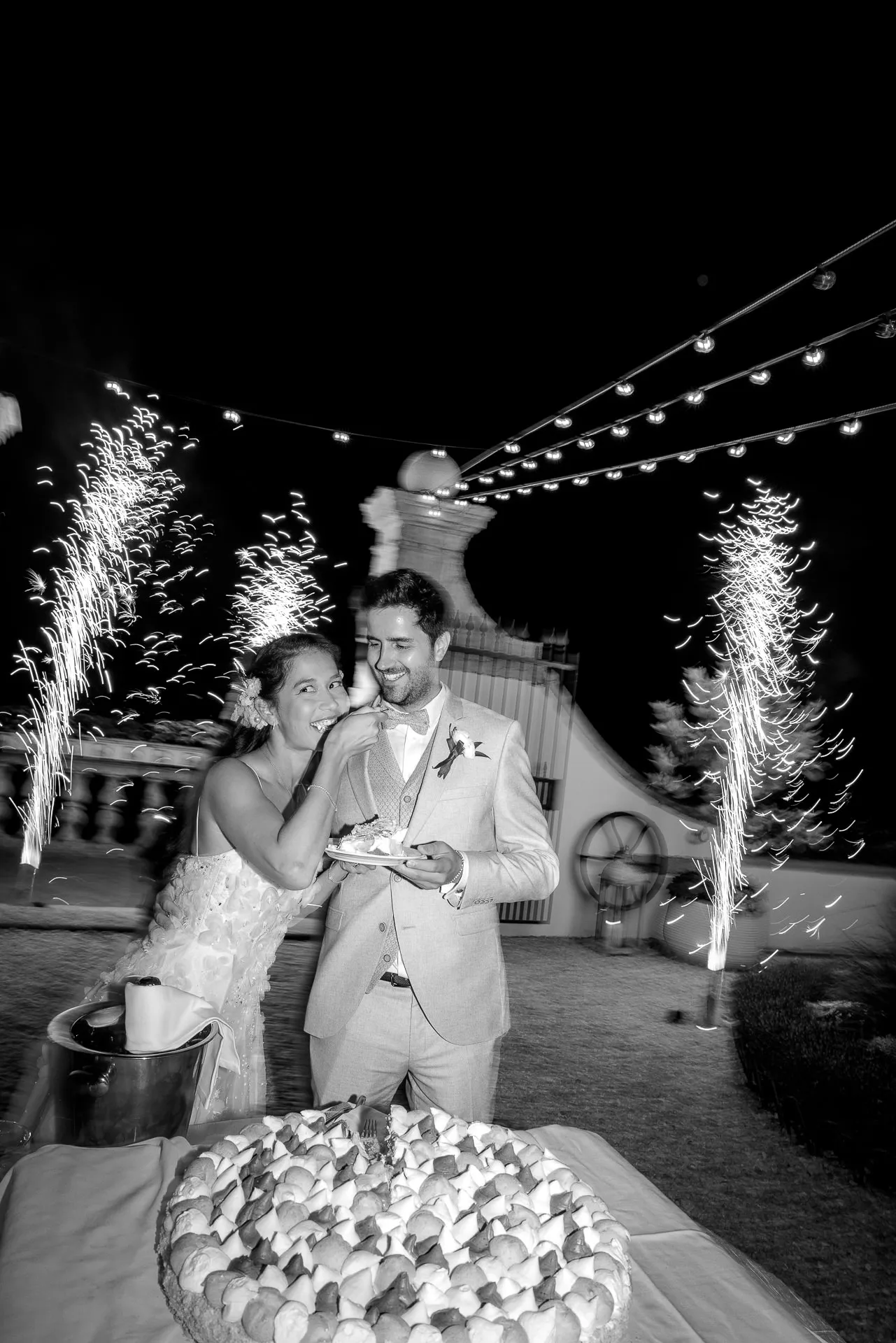 Brautpaar schneidet Hochzeitstorte mit Feuerwerk bei luxuriöser Hochzeit in Italien